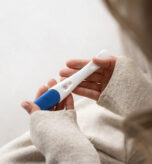 side-view-woman-holding-positive-pregnancy-test