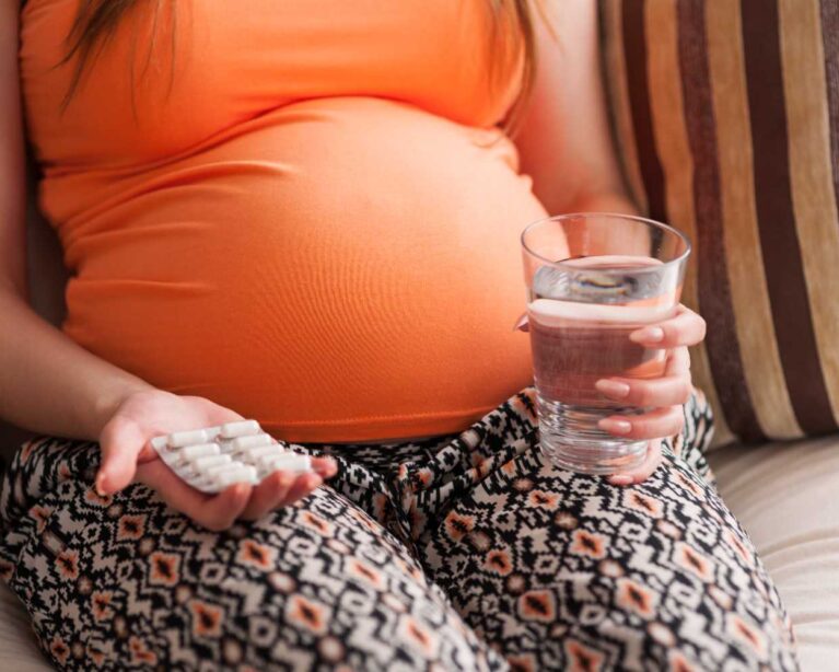 Pregnant woman staying hydrated to reduce the effects of extreme heat during pregnancy