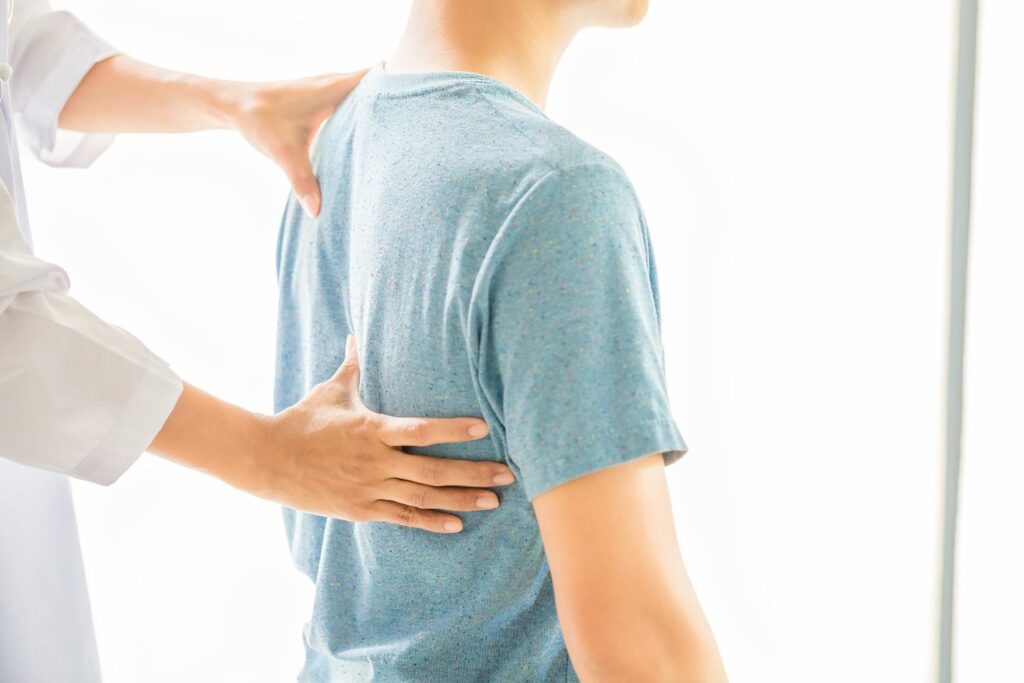 Orthopedic specialist assessing a patient's spine and back pain