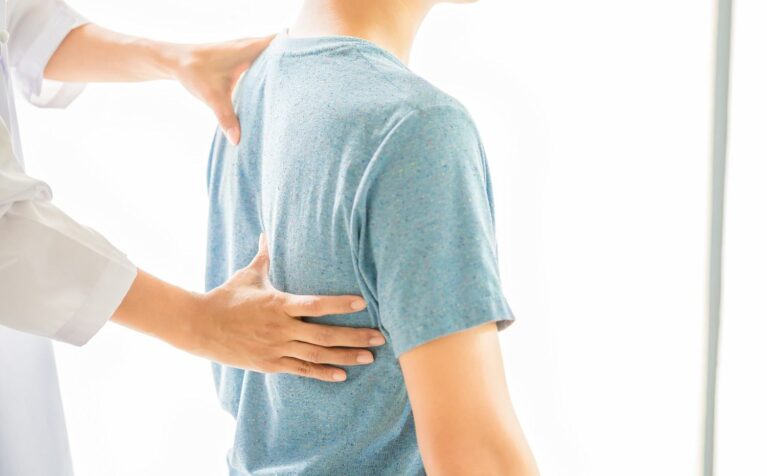 Orthopedic specialist assessing a patient's spine and back pain